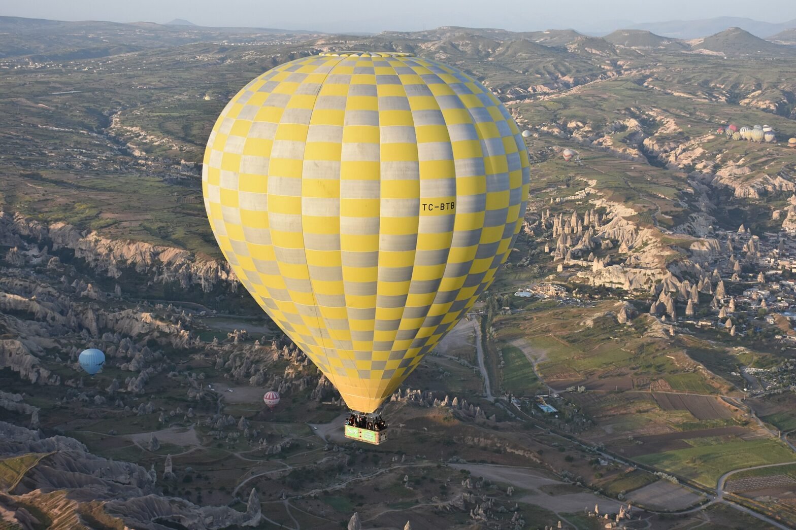 Hot air balloons flying over the Cappadocia valley in Türkiye at sunrise